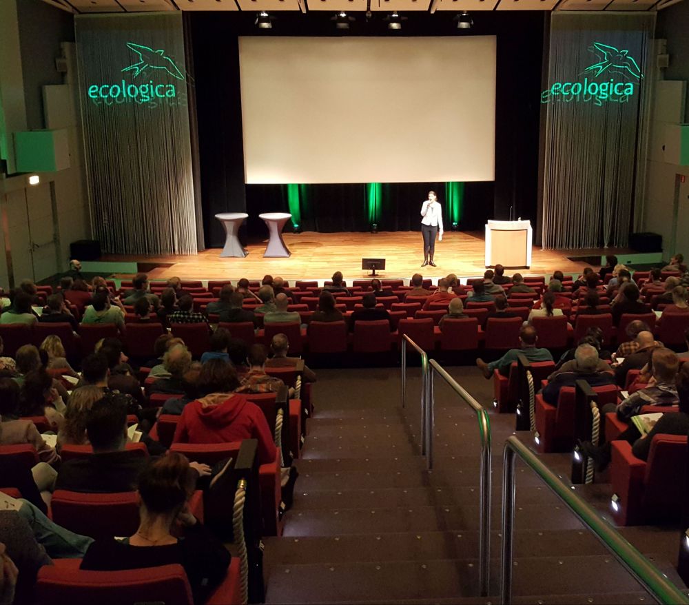 Karin Albers spreker voor grote zaal Oude plataan